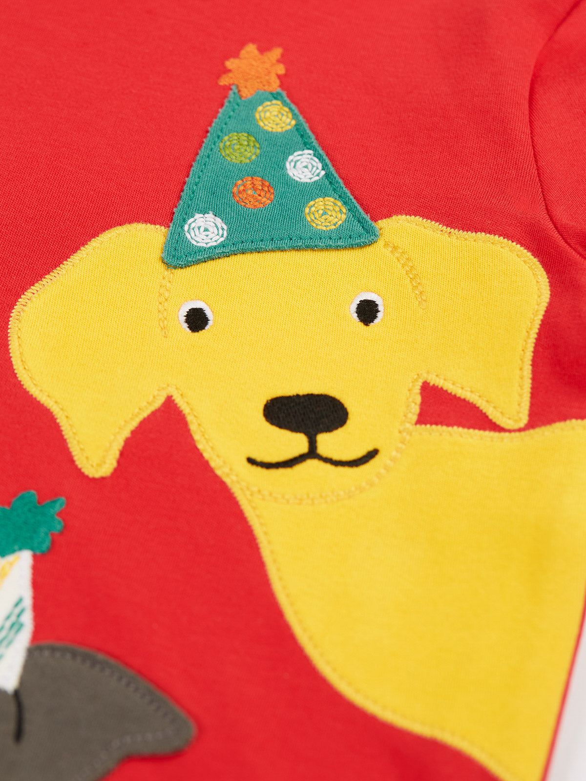 Frugi Adventure Langarmshirt Rot – Detail gelber Hund mit Partyhut