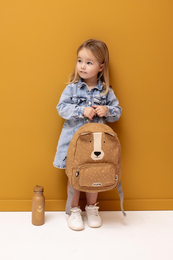 Kind mit kleinem Trixie Kinderrucksack Mr. Bear und Trinkflasche in Ocker