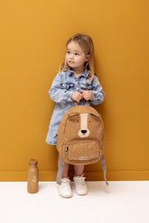 Kind mit kleinem Trixie Kinderrucksack Mr. Bear und Trinkflasche in Ocker